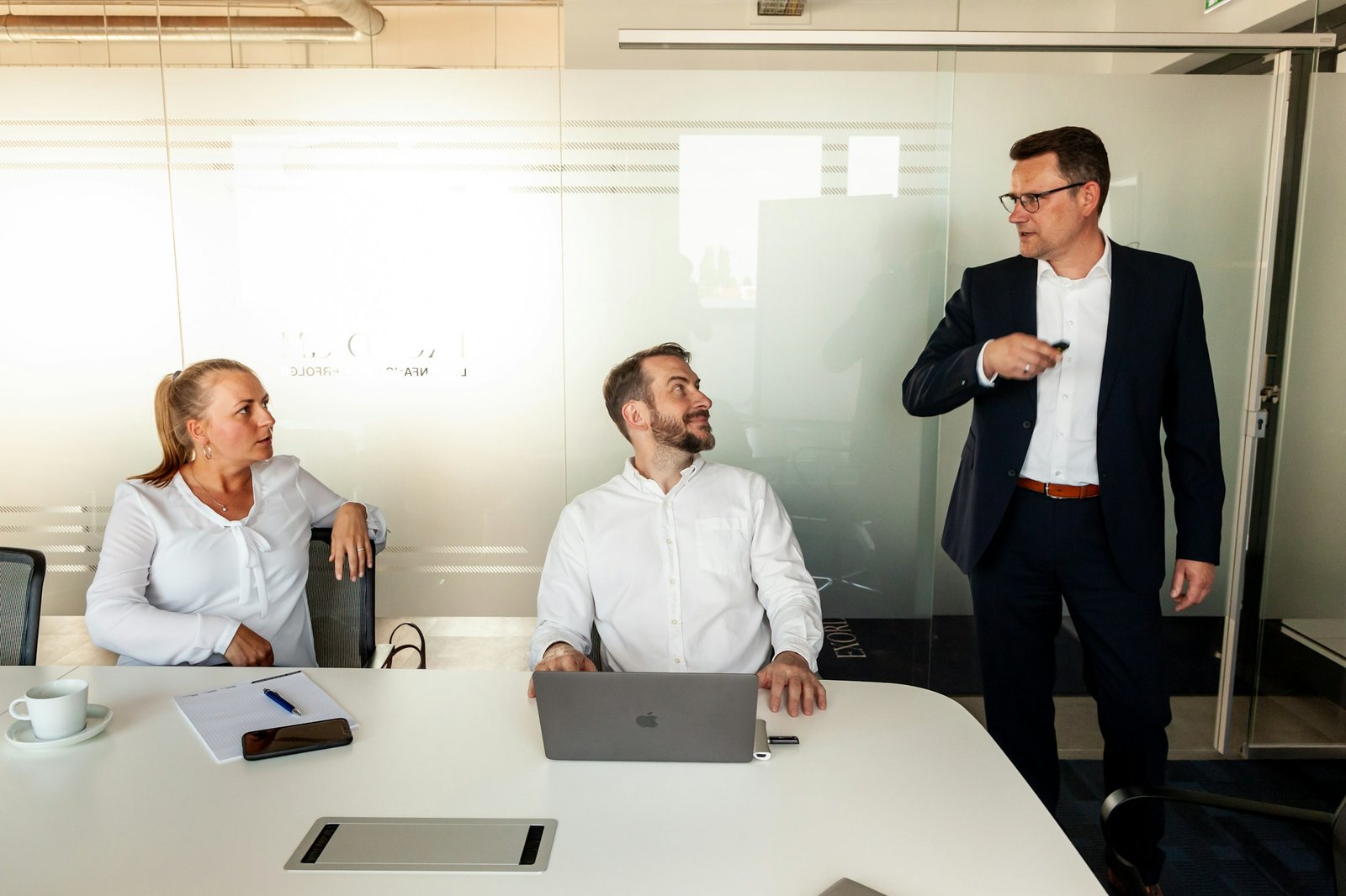 Drei Fachleute besprechen eine Zusammenarbeit in einem modernen Büro